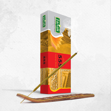 Janak 555 Incense Sticks box beside an incense stick in a wooden holder