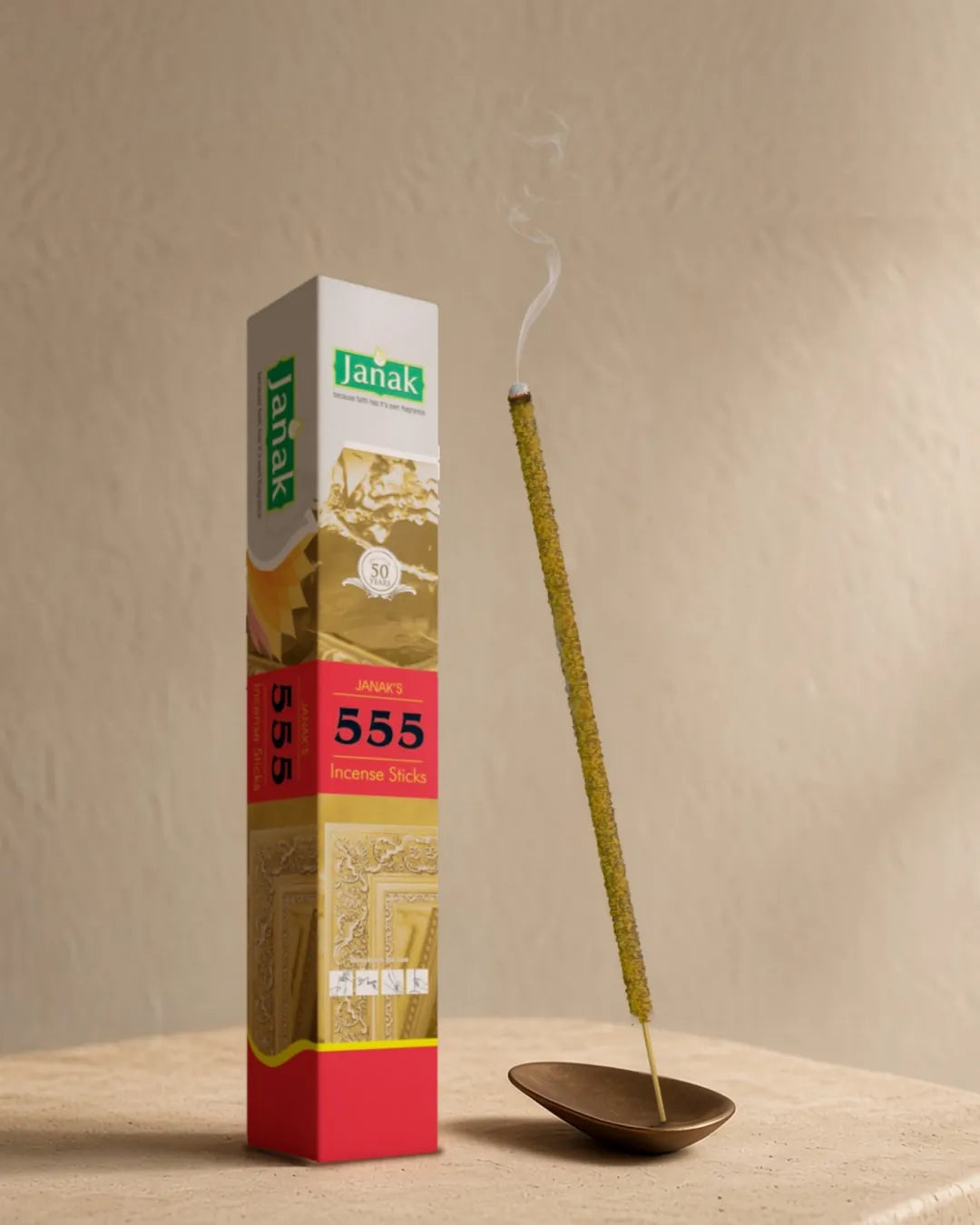 Janak 555 incense box with a lit 555 stick on a stone table